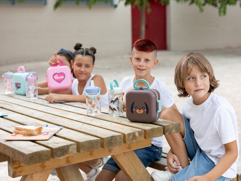 Grupo de alumnos en la zona de recreo con porta meriendas y sandwicheras infantiles.