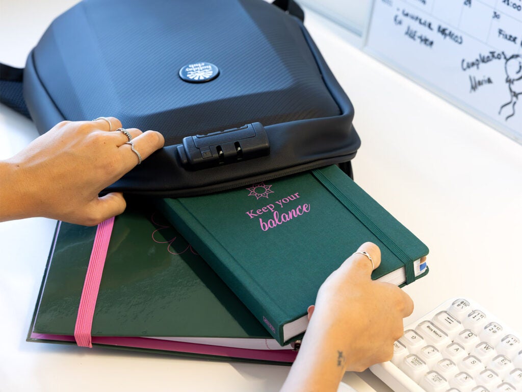 Guardando agenda anual verde en mochila de oficina