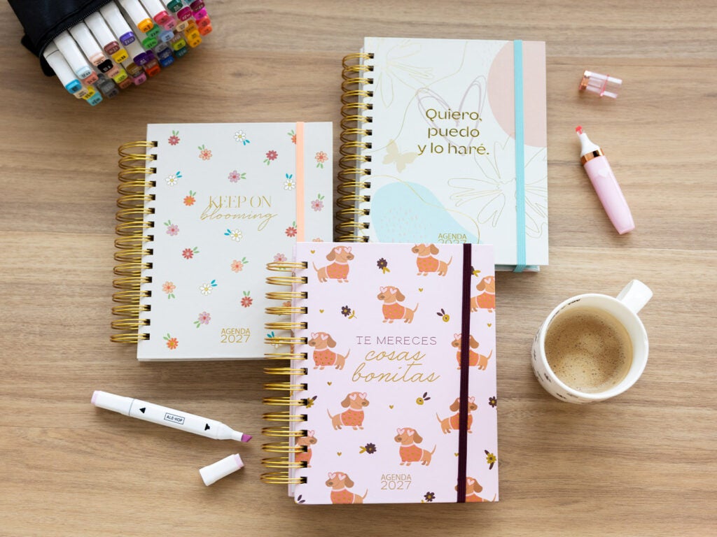 Agendas anuais aesthetic 2027 com espiral dourada e frases
