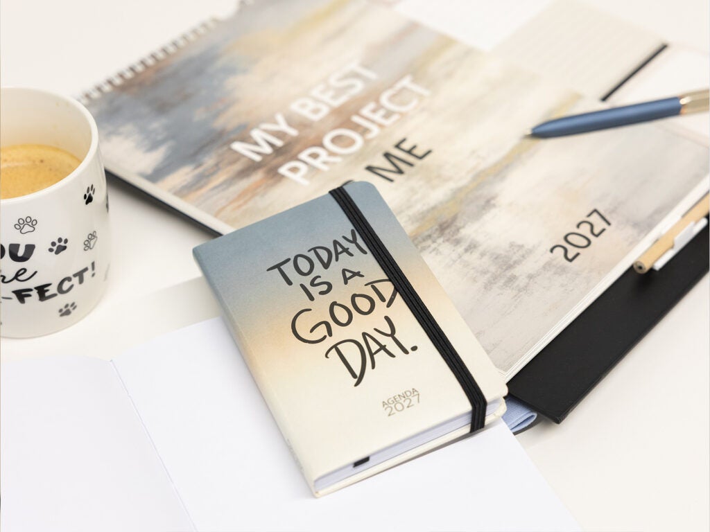 Agenda anual de bolso 2027 com frase positiva e caneta