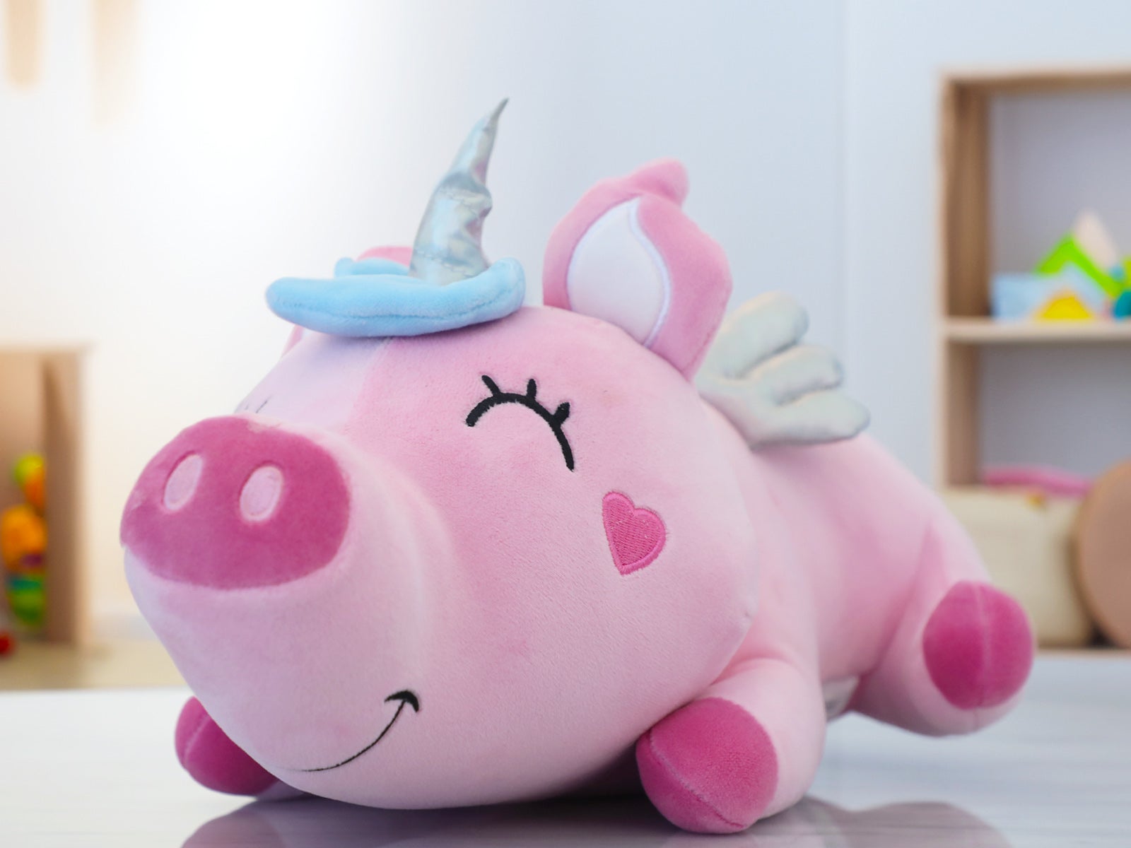 Peluche acostado cerdicornio